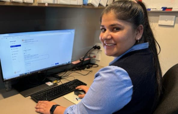 A staff member creating a Brenna update at her desk